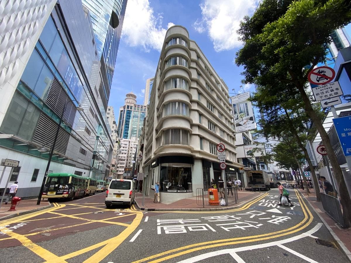 A Causeway Bay street corner with a curved white building and painted road markings