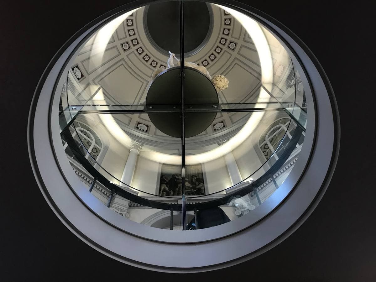 A circular gallery seen from below, rings of white balustrade rising into a dome