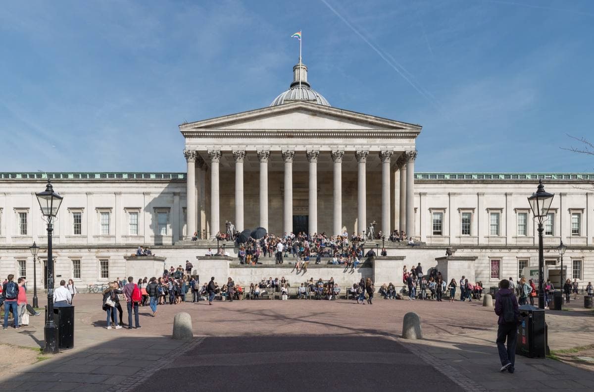 A domed neoclassical portico above a broad quad with people sitting on the steps