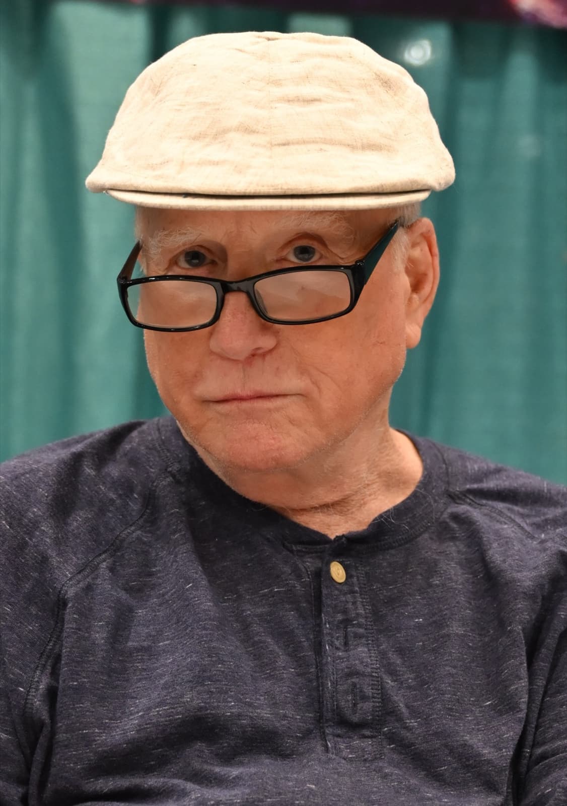 Richard Dreyfuss in a pale flat cap and glasses