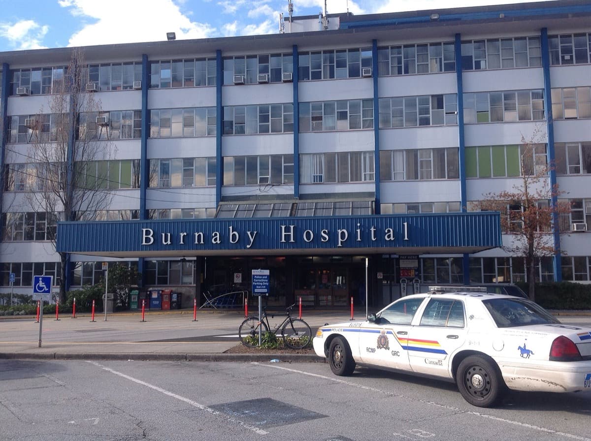 A hospital entrance with a police car parked outside