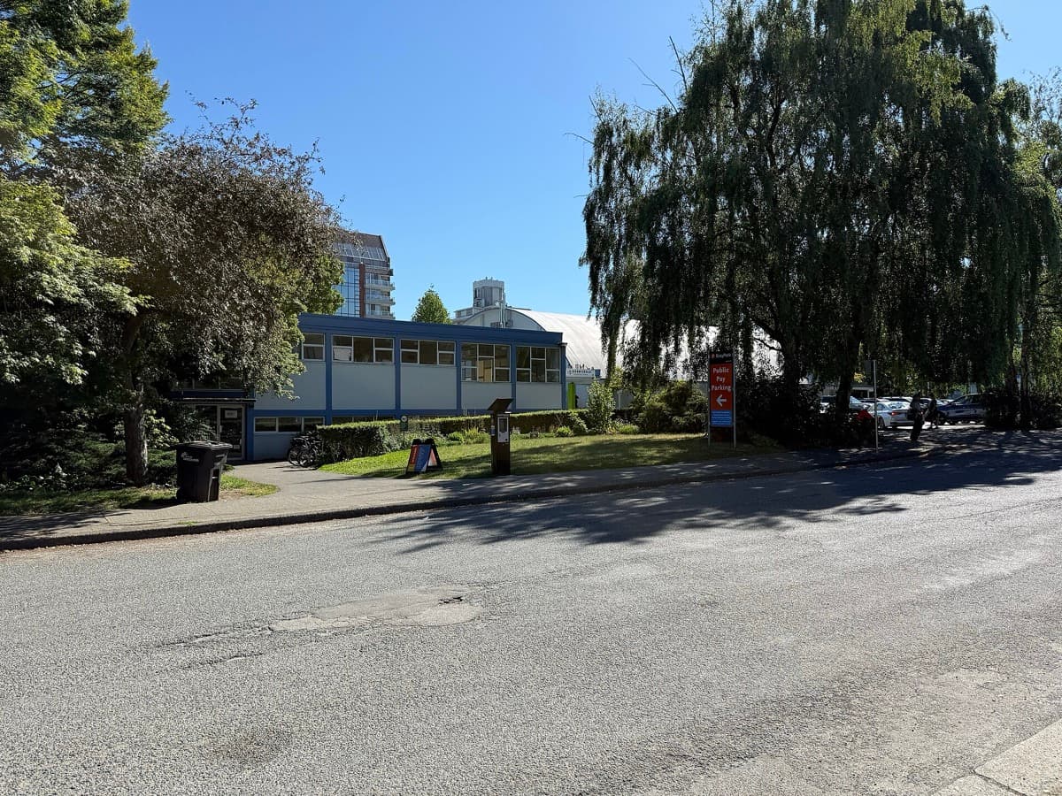 A low community centre building with trees in front