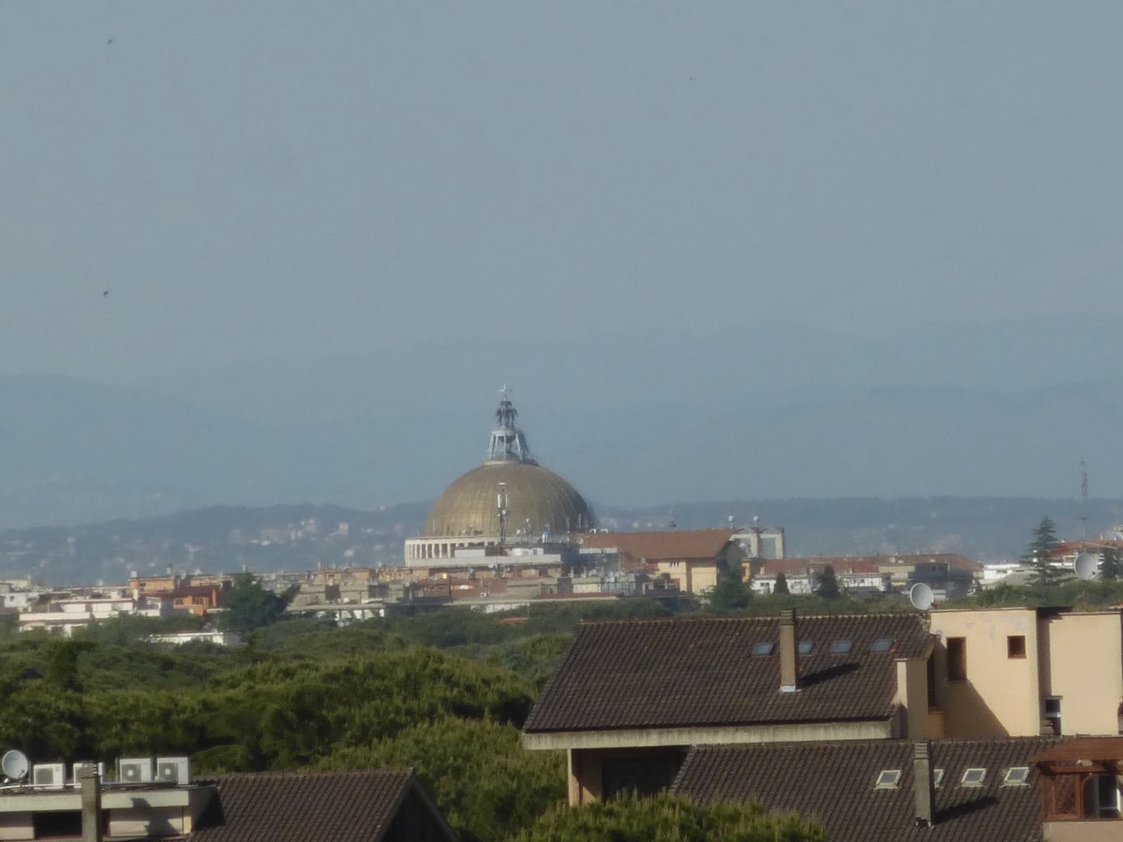 A large ribbed dome rising above the roofs of a Roman suburb