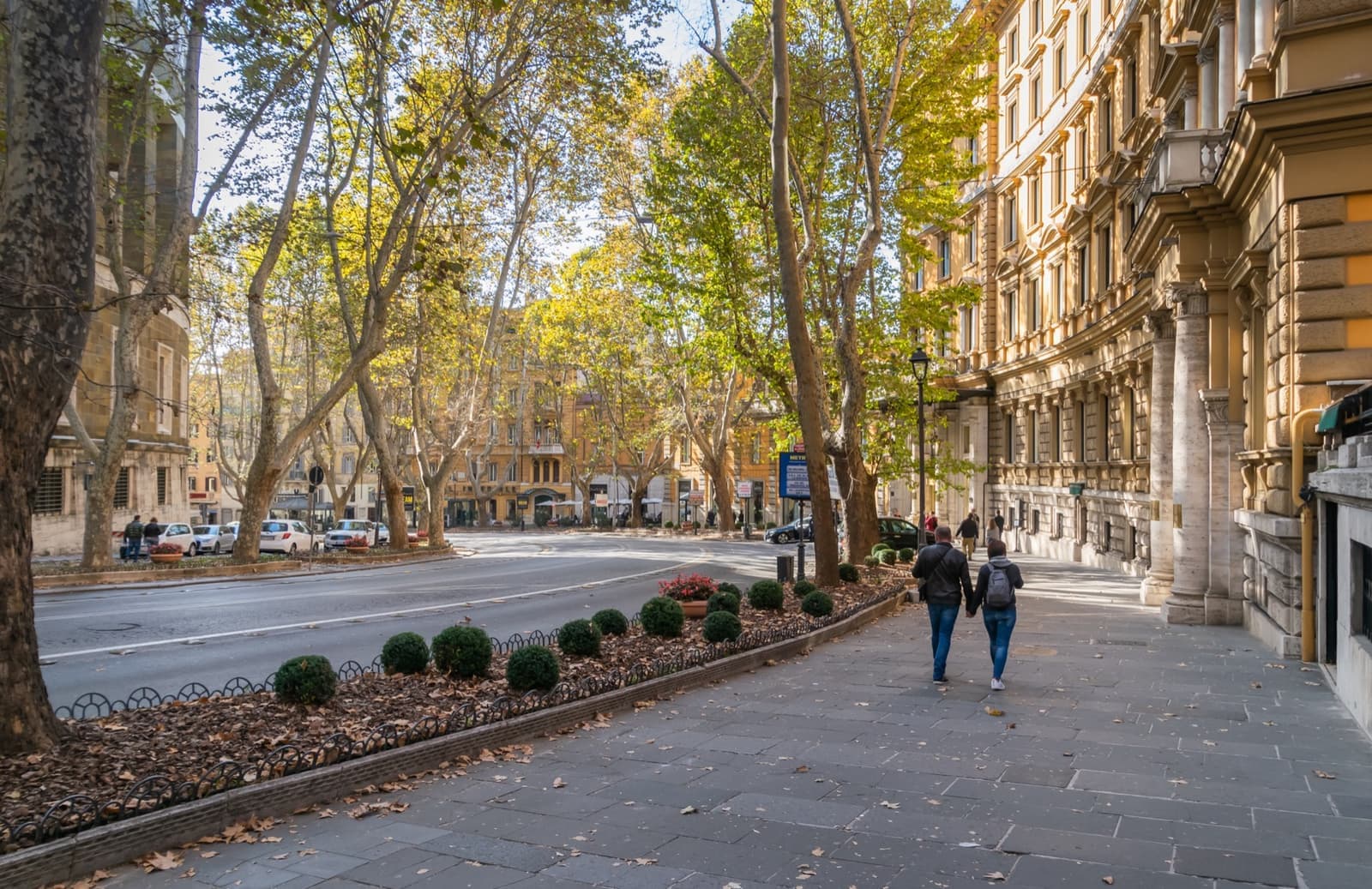 A curving avenue of plane trees and grand hotel fronts in autumn