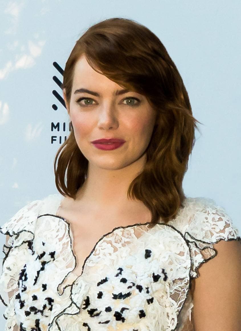 Emma Stone with auburn hair in a white lace dress, head and shoulders