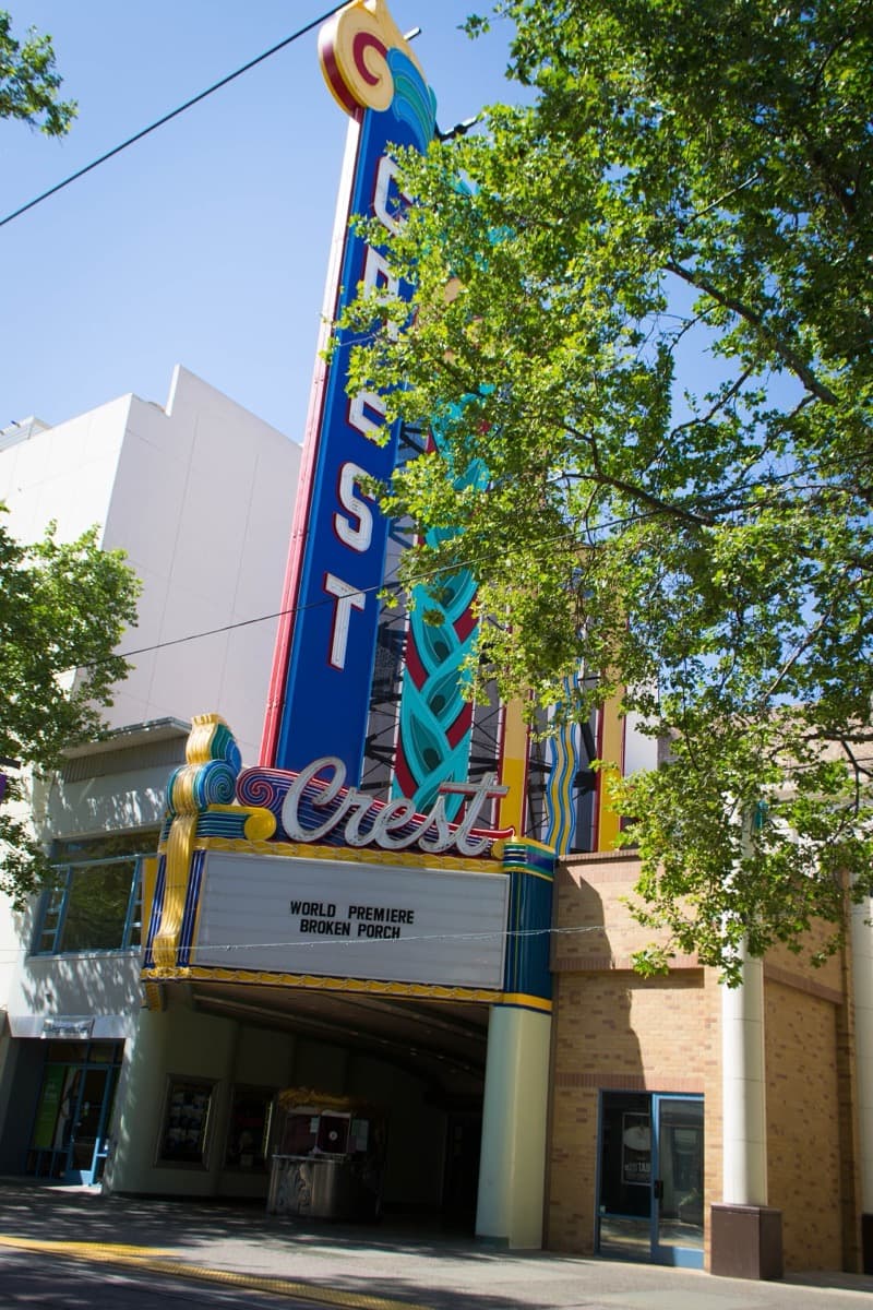 A tall neon marquee on a cinema front on a city street