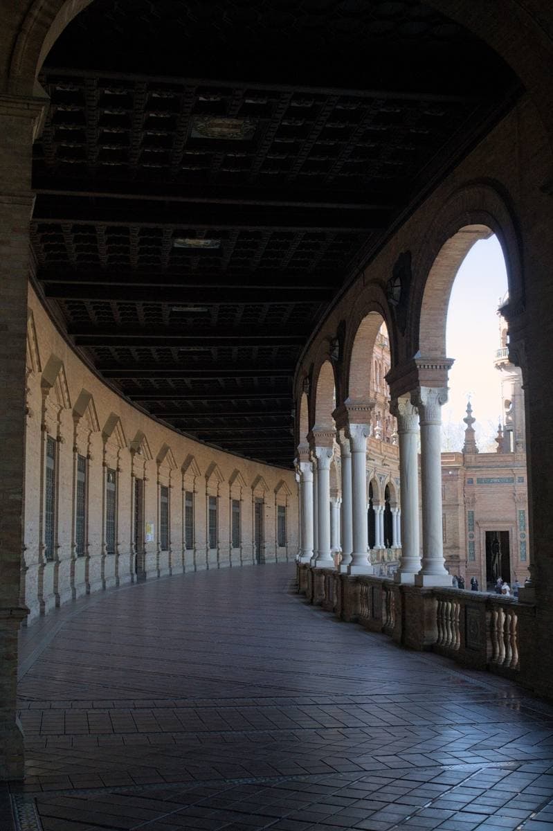 A long curving gallery of brick arches with a coffered ceiling