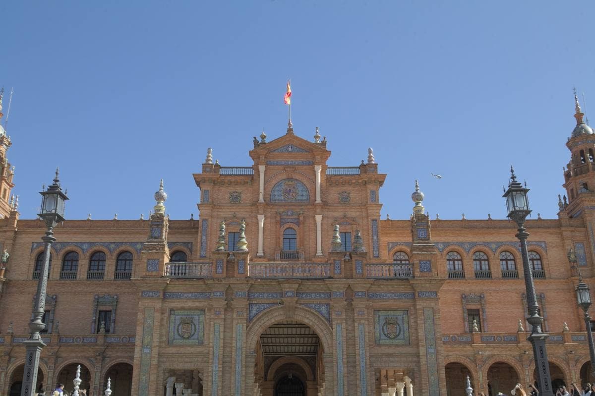 A brick and stone palace front with towers, balconies and tiled panels