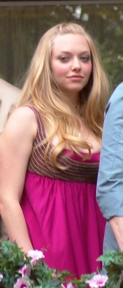 A young woman with long blonde hair in a pink dress
