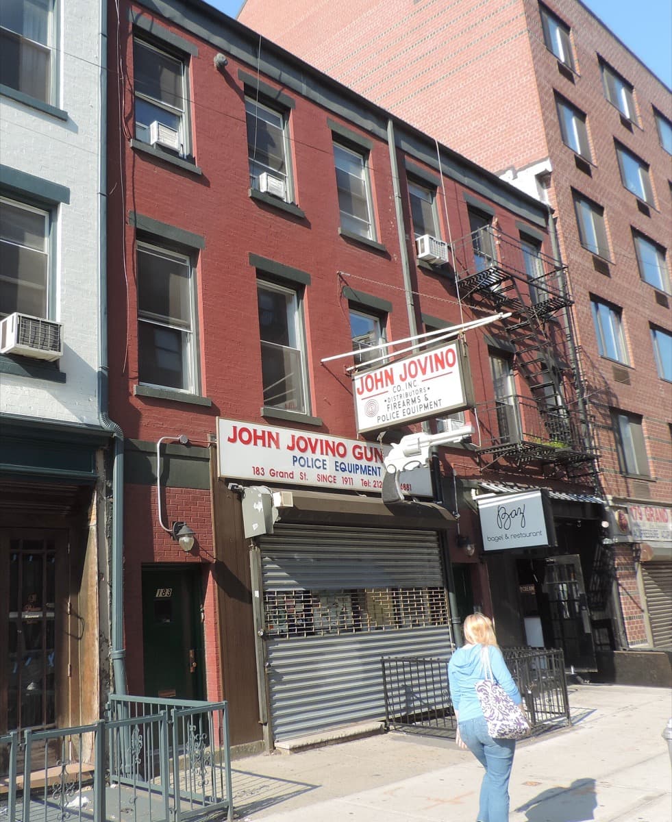 A narrow shop front with hand-lettered signs on Grand Street