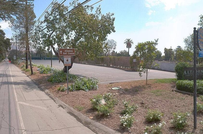 A planted verge with an Altadena Golf Course sign beside a quiet road