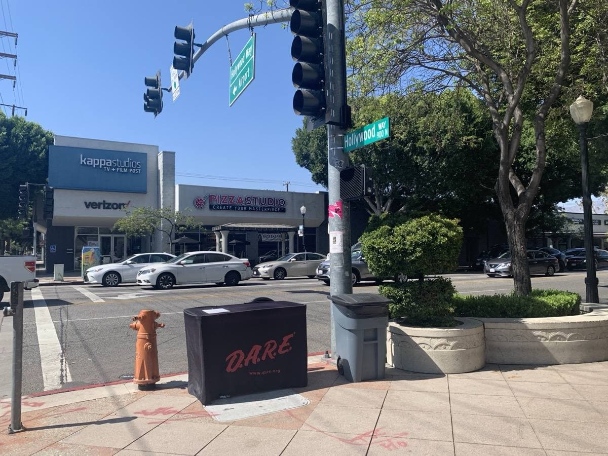 A street corner on Magnolia Boulevard with traffic lights and shops