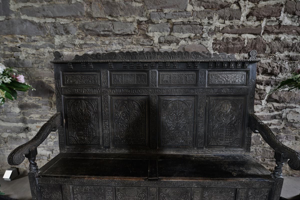 A carved wooden seat inside the stone Great Hall at Doune Castle.