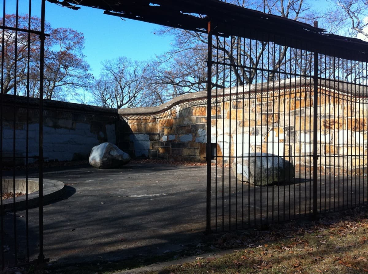 A rusted iron cage set into a stone wall