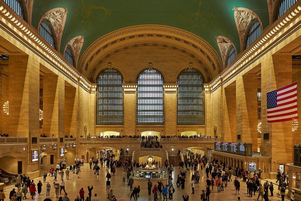 A vast hall with a painted ceiling and a central information booth