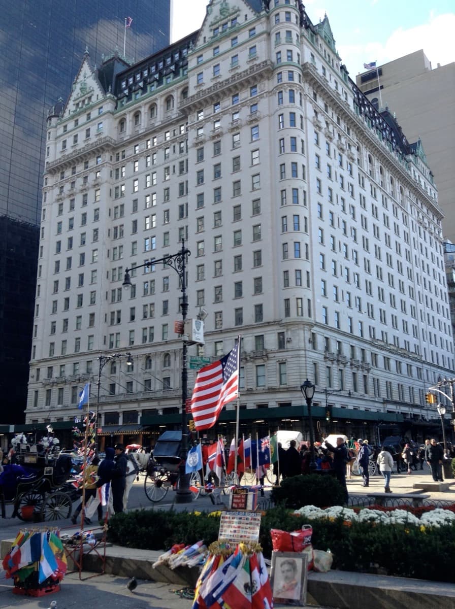 A cream-coloured château-style hotel tower seen from across the street