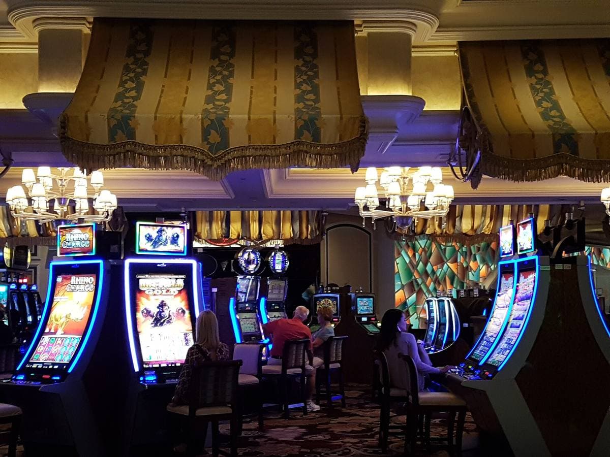 Slot machines and tables under striped canopies and chandeliers