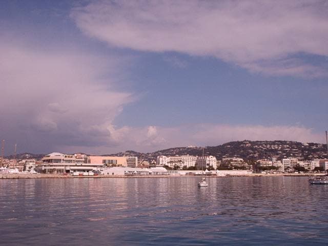 The Cannes seafront seen from a boat, with hills behind