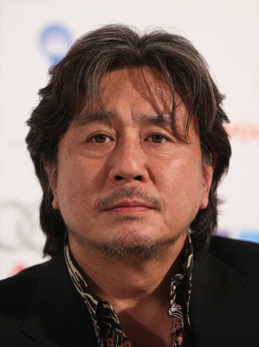 Choi Min-sik smiling at a film festival, in a dark jacket