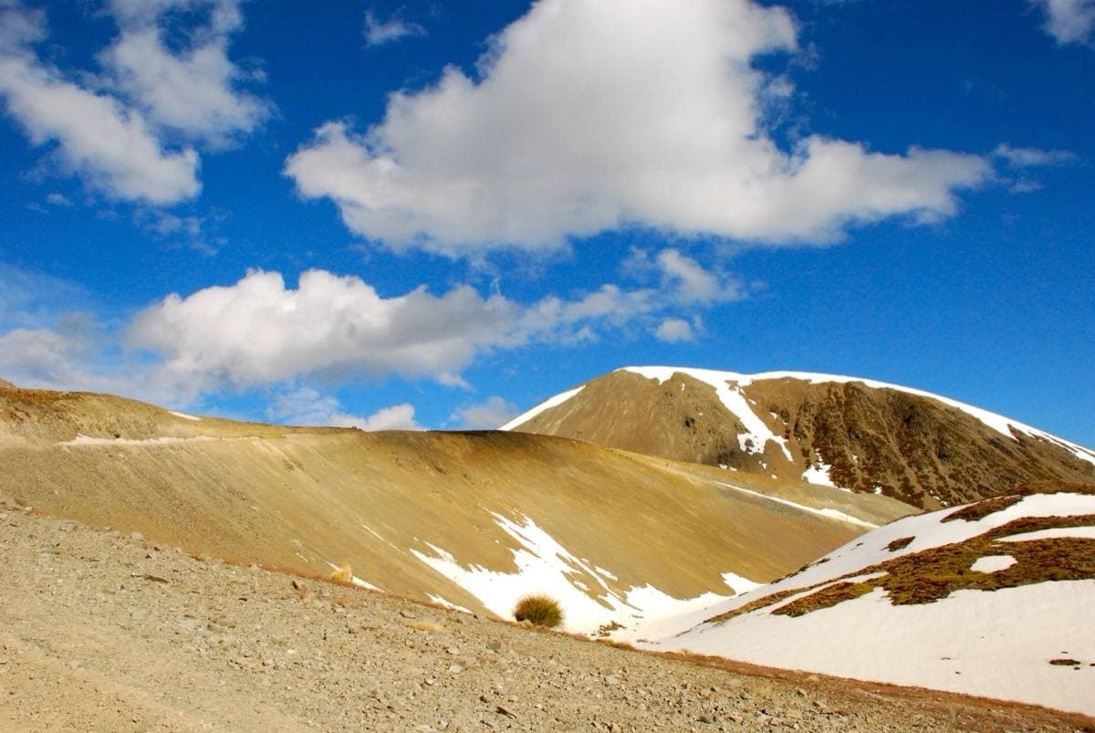 A snow-covered mountain summit under a pale sky