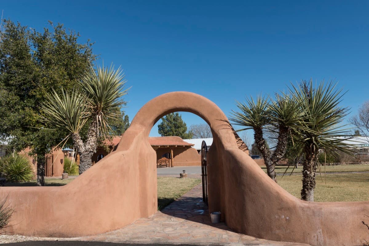 A motel entrance sign beside a desert road