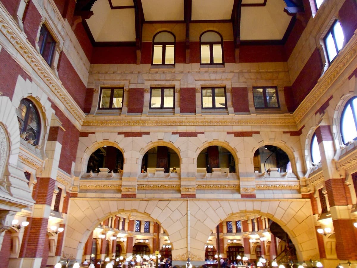 The tall interior of a Victorian library with iron galleries and tall windows