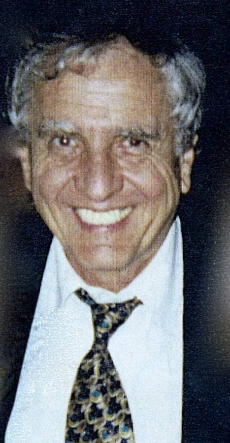 Garry Marshall, grey-haired and grinning, in a white shirt and patterned tie