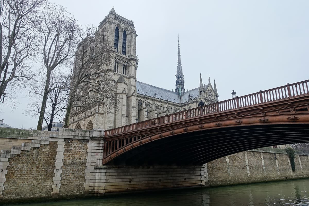A grey stone bridge over the Seine with the towers of Notre-Dame beyond