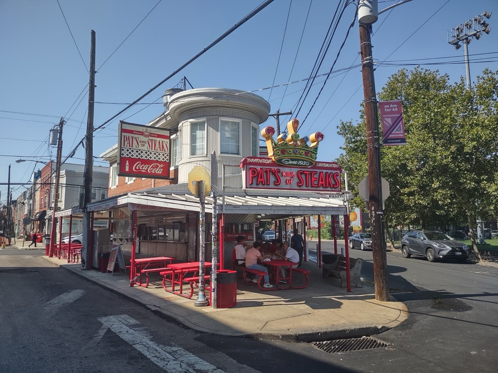 Pat’s King of Steaks, a corner stand with red-and-white signs and outdoor counters