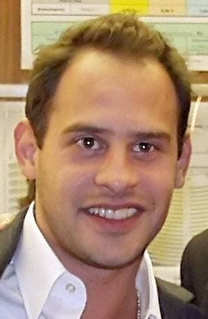 Moritz Bleibtreu smiling, in an open white shirt