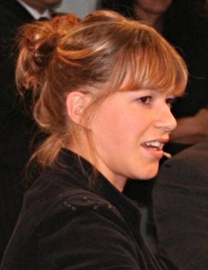 Franka Potente, smiling, her hair pinned up, talking in profile