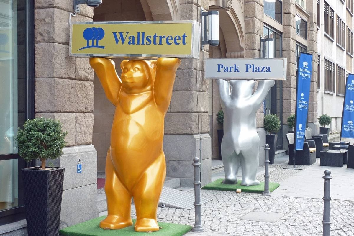 A golden bear sculpture holding a Wallstreet sign outside a hotel door