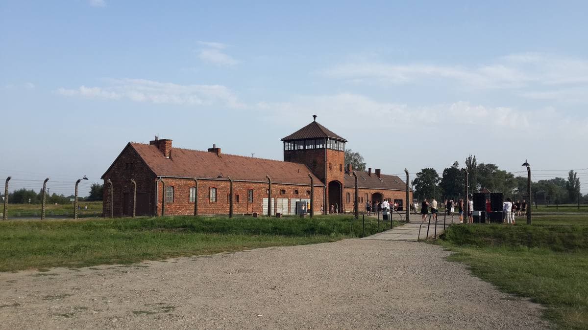 A long low brick gatehouse with a central tower under a pale sky