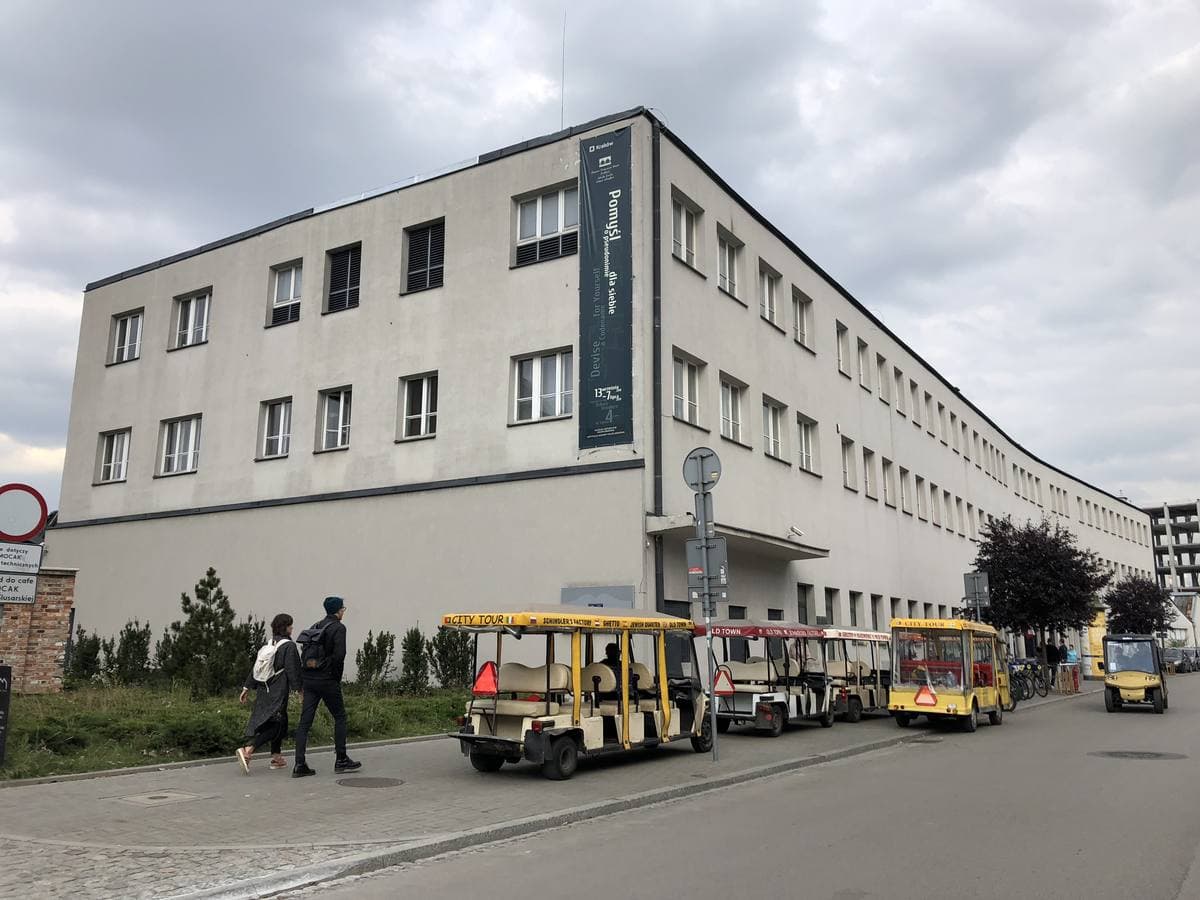 A long pale three-storey building with a banner by its entrance