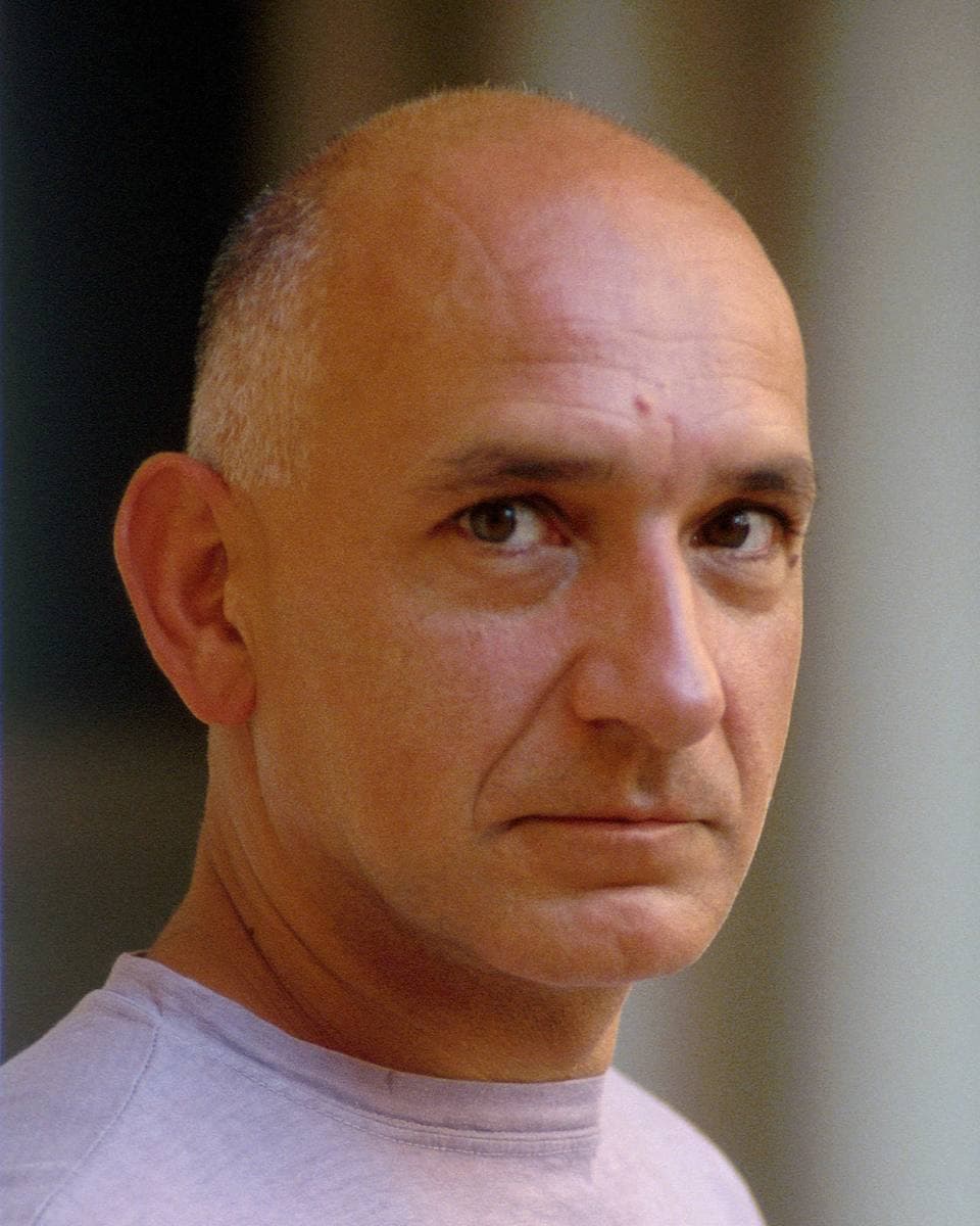 Ben Kingsley, bald, looking straight at the camera