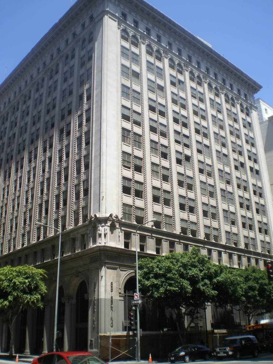 A tall Beaux Arts bank building with columns on a downtown corner