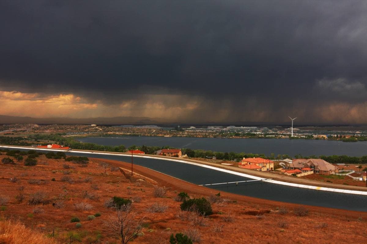 Flat desert scrub under a dark storm sky