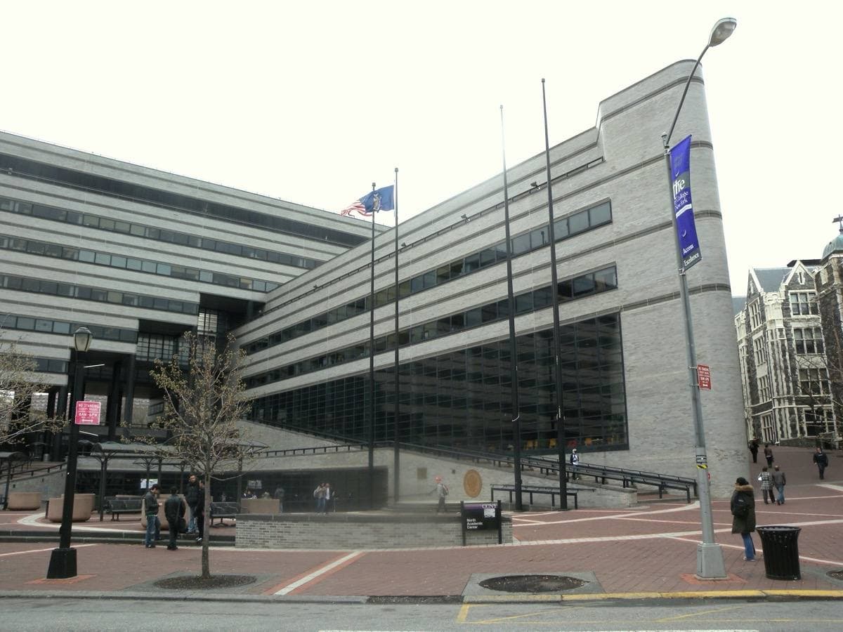 A long modern college building on a hill