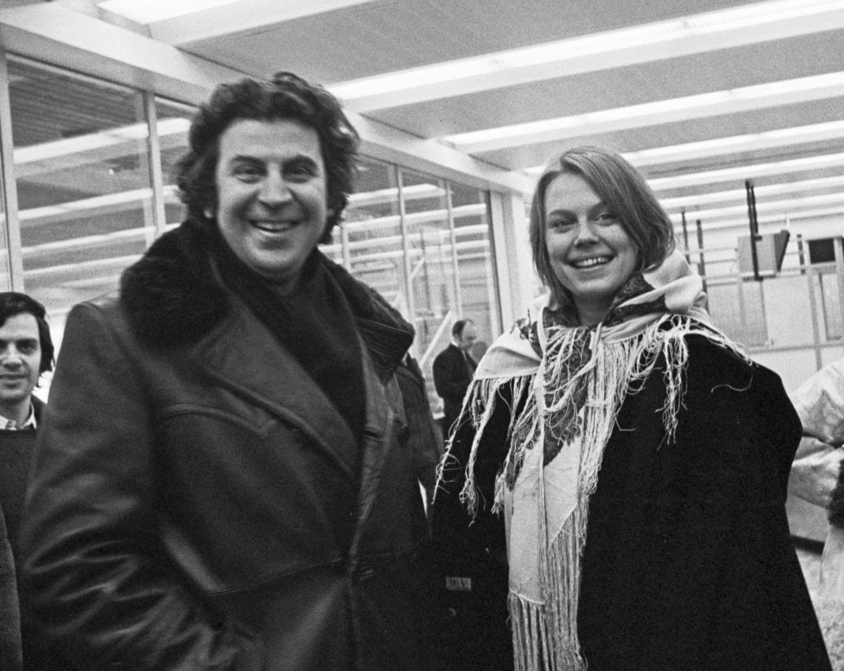 Mikis Theodorakis, curly-haired, at an airport