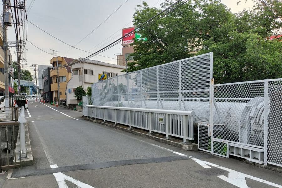 A road bridge over the Sengawa river at Ōkura, Setagaya, with a water main beside the bridge.