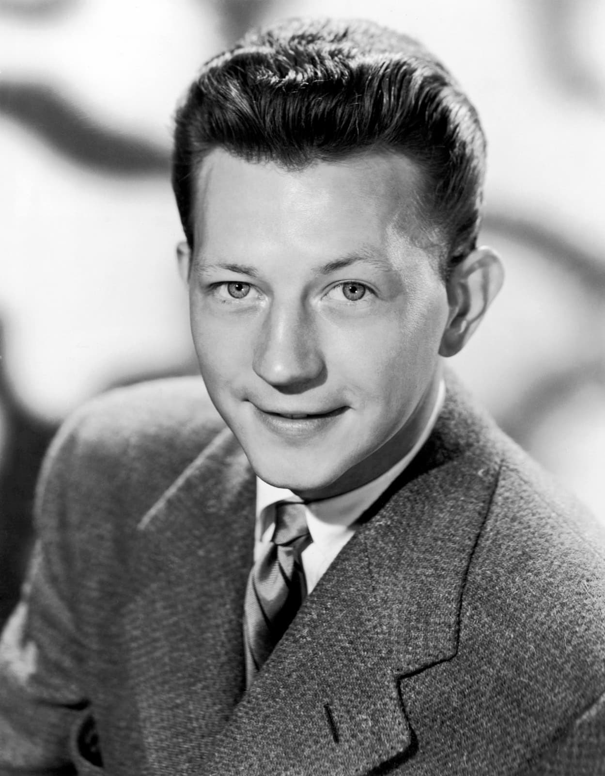 Donald O’Connor in a tweed jacket and tie, smiling