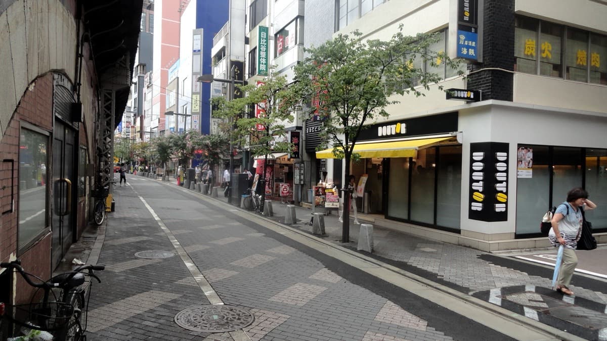A street with shops and a brick arch on the left