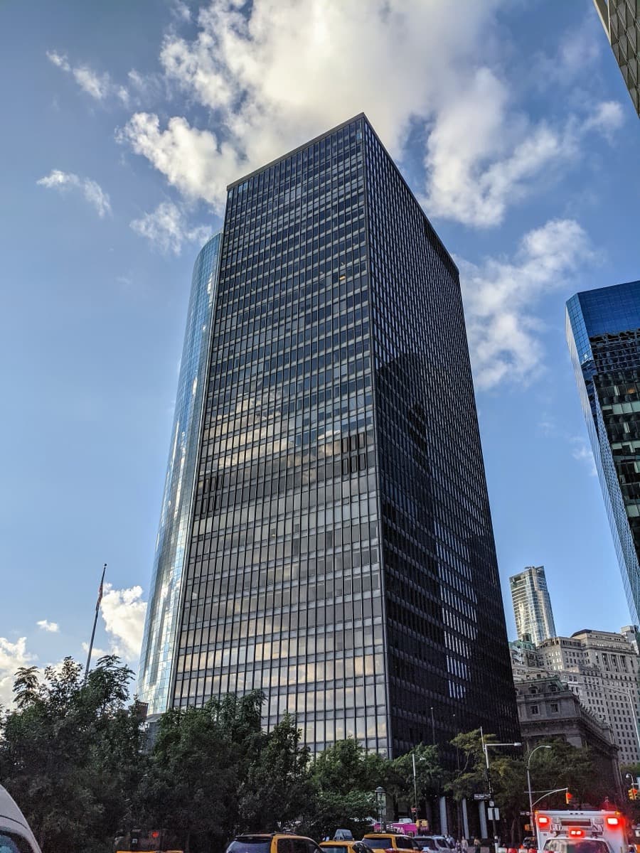 A curved glass and stone tower at the foot of Manhattan