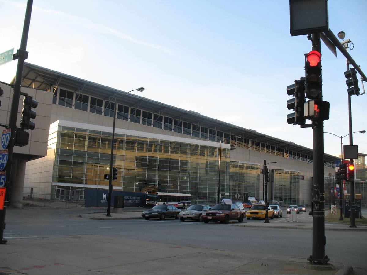 The long glass and steel front of McCormick Place beside a street with traffic lights