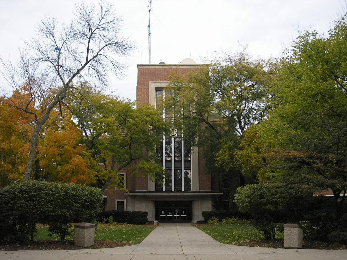 An Art Deco brick tower entrance framed by autumn trees