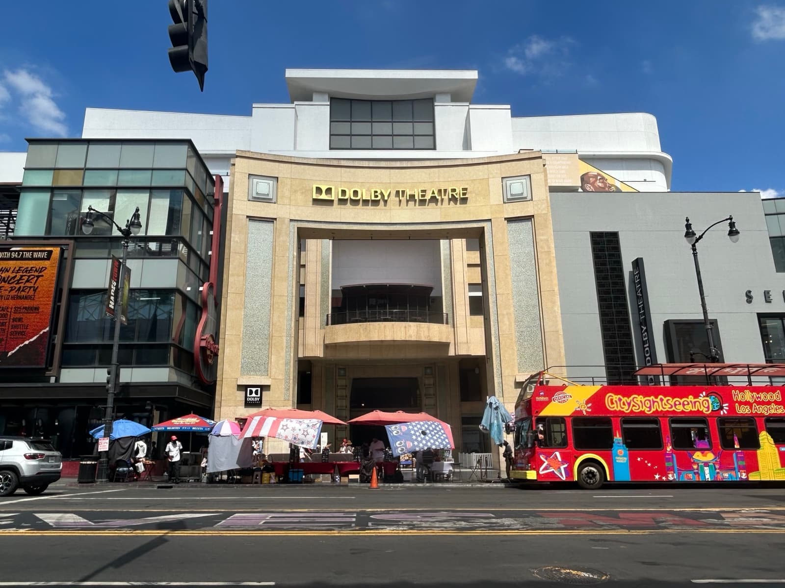 The tall entrance of the Dolby Theatre with a tour bus passing