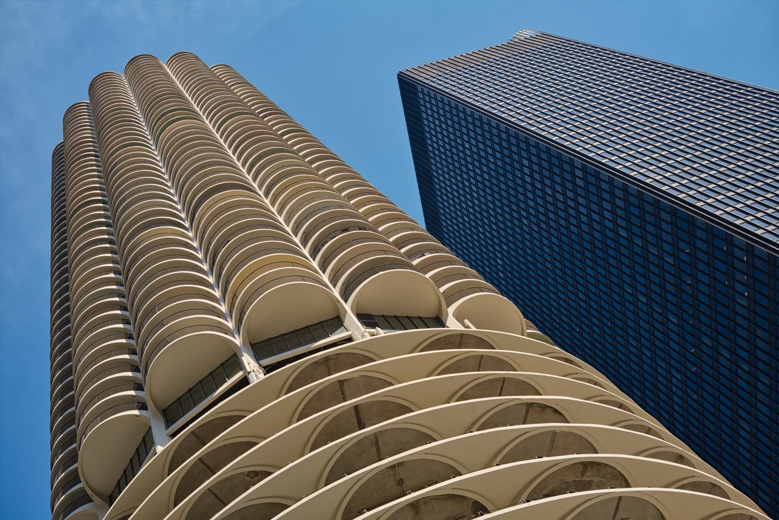The black steel grid of 330 North Wabash rising beside the curved balconies of Marina City