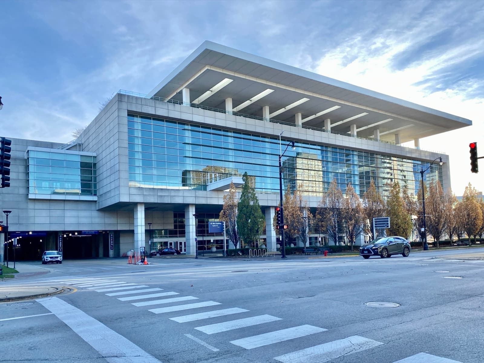 A glass convention hall under a wide flat cantilevered roof
