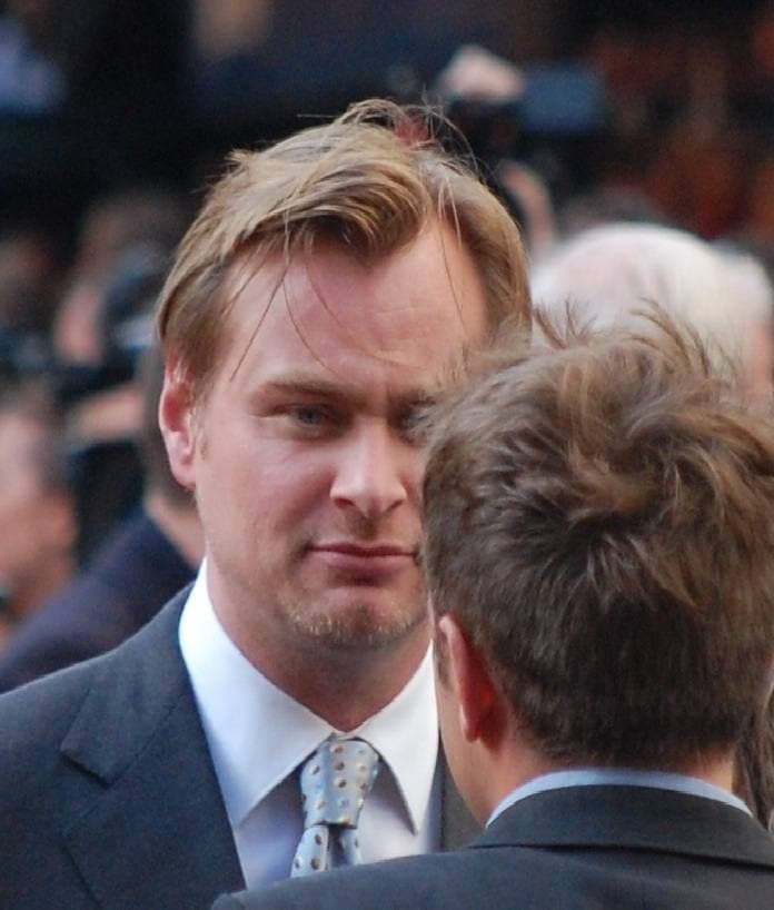 Christopher Nolan in a grey suit and tie at the London premiere