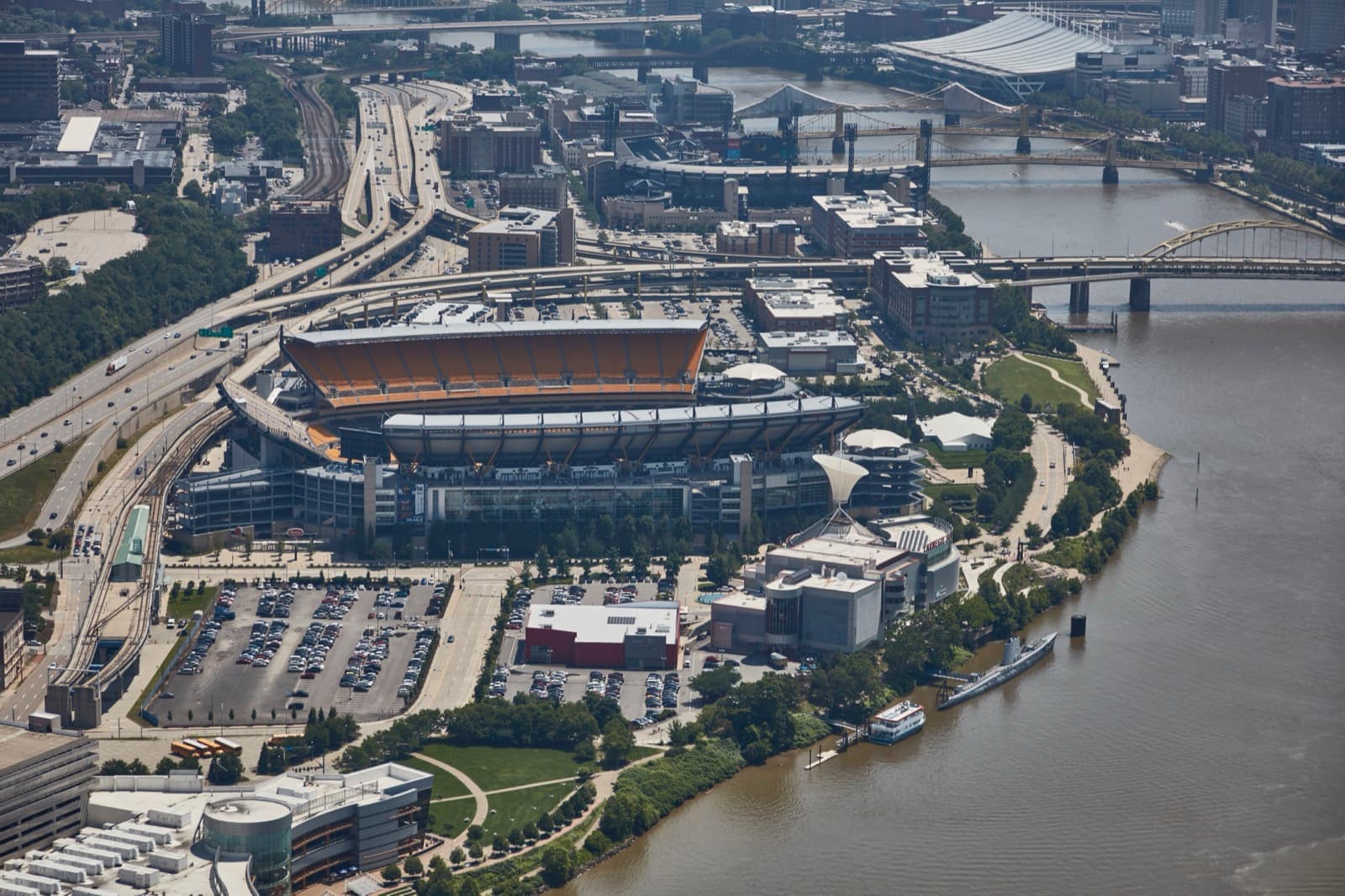 Aerial view of a horseshoe-shaped football stadium beside a river in Pittsburgh